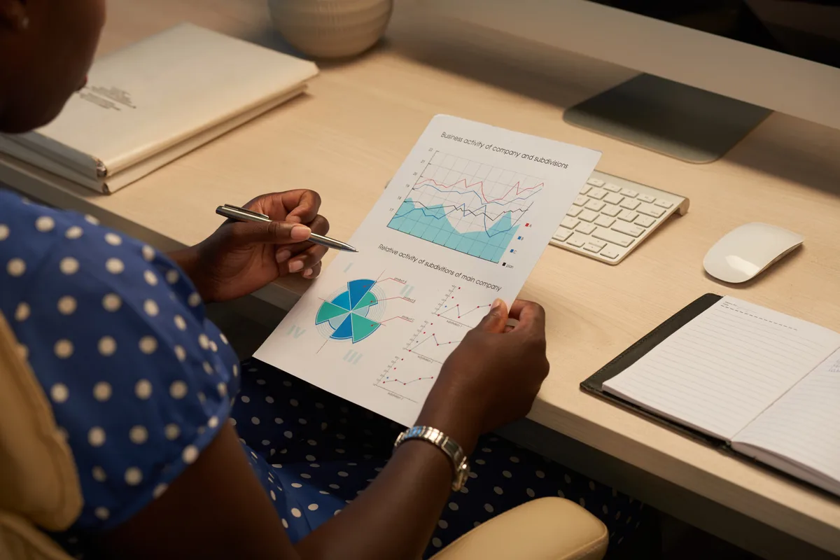 An analyst marking up printed charts of activity data at a desk
