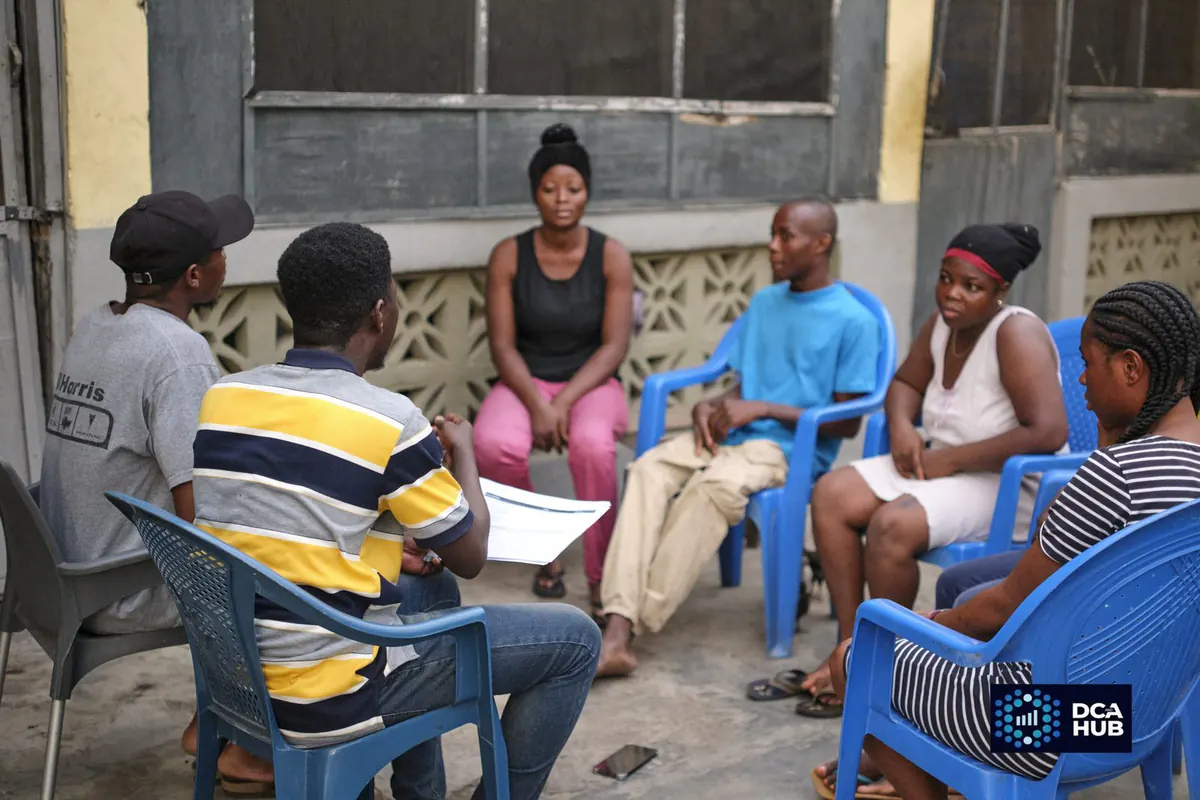 A focus group discussion in progress, participants seated in a circle while a facilitator works through a discussion guide